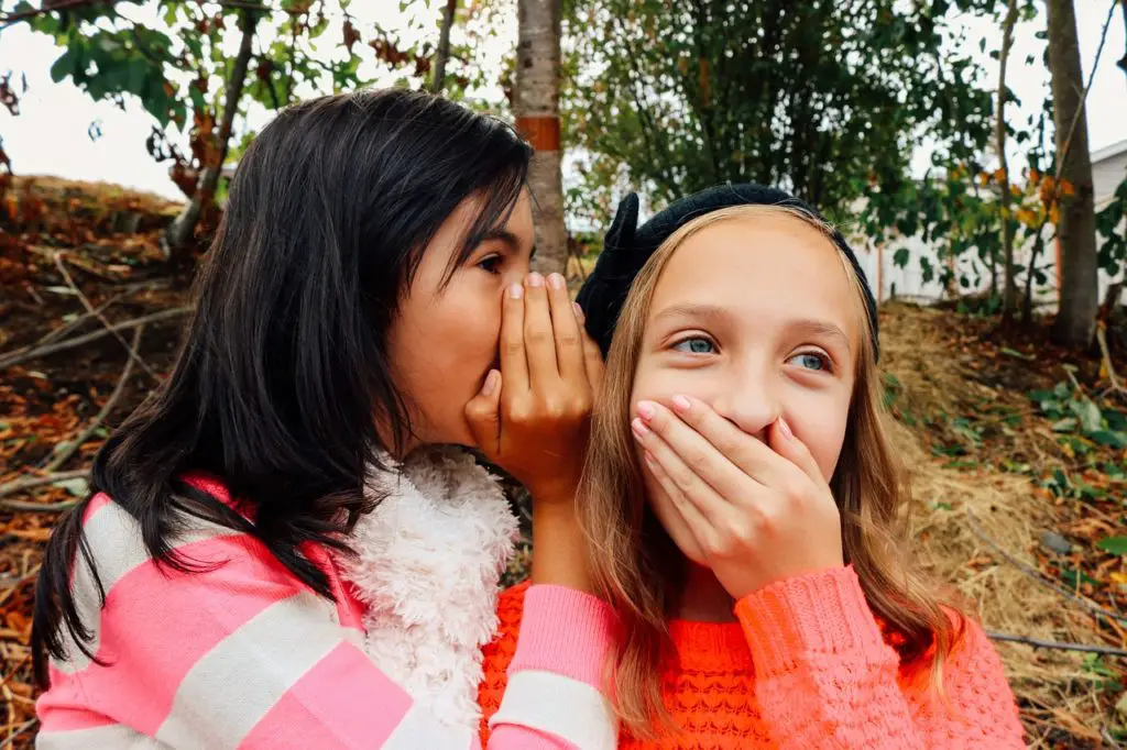two girls playing listening games - areas to build child's language